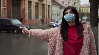 Woman try to stop taxi because of problem with traffic at bus station during covid 19 virus pandemic