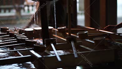 People taking water to clean their hand before enter japanese shrine temple