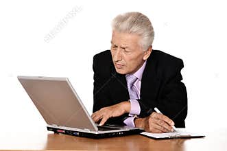 Portrait of old businessman working with laptop