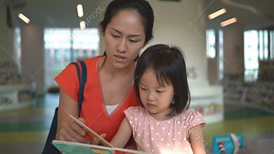 4K Slow motion of asian parent and child reading at the library