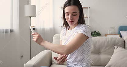 Young attractive woman applying moisturizing cream on elbow.