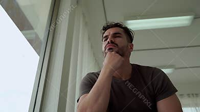 Mental health, men sitting stressed by the window, in an epidemic condition covid -19, causing him to lose his job