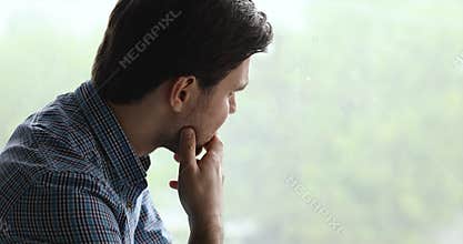 Man looking out the window feels unhappy goes through divorce