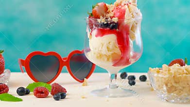 Making gourmet berry and vanilla ice cream sundae