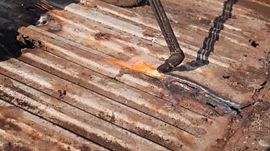 Cutting metal sheet at the scrap yard with oxygen cutter, close up