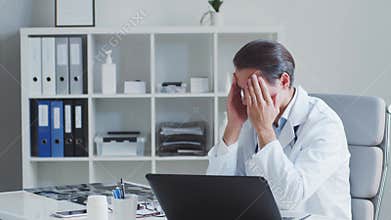 Tired and stressed medical doctor working in hospital office