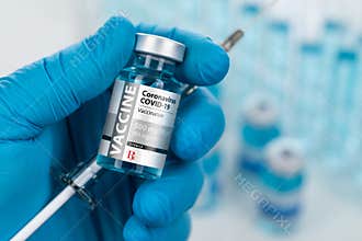 Surgical Glove Holding Coronavirus COVID-19 Vaccine Vial and Syringe