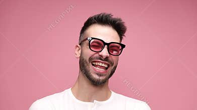 young casual man in white shirt posing on pink background