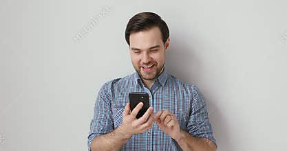 Emotional young man using funny mobile applications.
