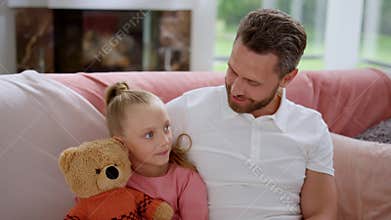 Daughter having conversation with father in room. Parent and kid talking at home