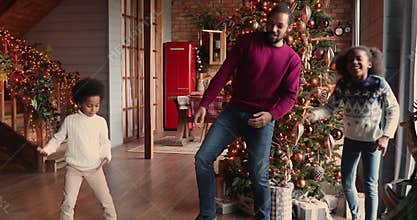 African family dancing in decorated living room on Christmas Eve