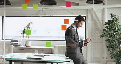 Focused young businessman in formal wear using tablet in office.