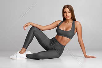 Beautiful athletic girl, fitness woman on gray background