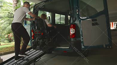 Disabled person on wheelchair using van ramp