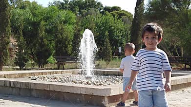 Adorable children siblings watching the fountain,Toddlers brother walking camera