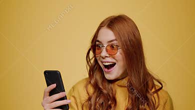Surprised girl getting good news on mobile phone. Woman looking cellphone screen