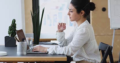 Indian female employee thinking over issue sitting at office workplace