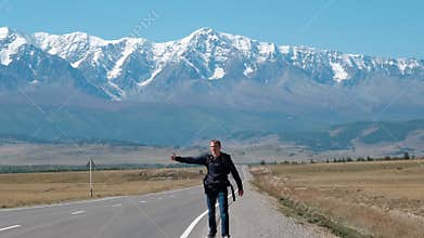 Man Backpacking Hitchhiking on a Mountain Road