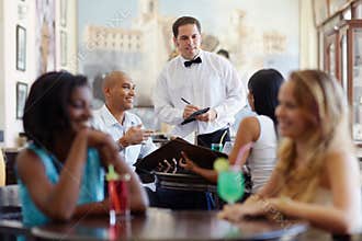 People ordering meal to waiter in restaurant