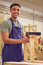 Portrait Of Male Student Studying For Carpentry Apprenticeship At College Using Set Square