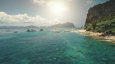Aerial sun beach at ocean bay pier with boats, vessels on water. Relax of tourists on tropic island