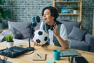 Joyful kid recording audio about football holding ball talking in microphone