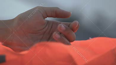 Hand of shipwreck victim holding life vest, global catastrophe, close-up