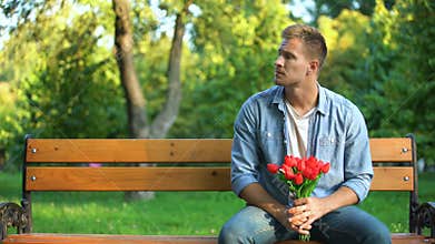 Man with bunch of flowers tired of waiting girlfriend, walking away, bad date