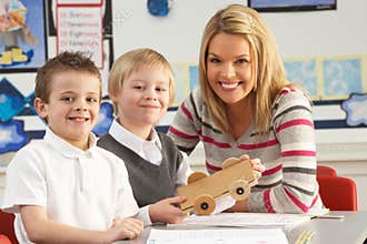 Two Male Primary School Pupils And Teacher Working
