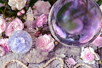 Still life with magic crystal ball, pink roses and necklace