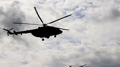 Helicopter silhouette flies in the sky close up