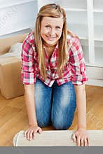 Happy woman rolling a carpet out