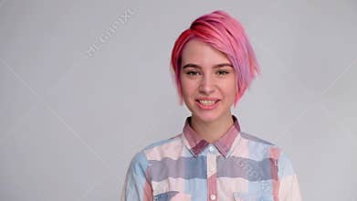 Young beautiful girl with a short hair cut pixie bob. Color hair coloring, red pink color. Shirt in a cellar, casual