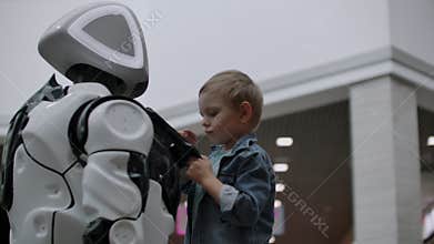 Humanoid robot talks with child at technology exhibition. The Exhibition Park Of Robots. Humanoid robot talks with.