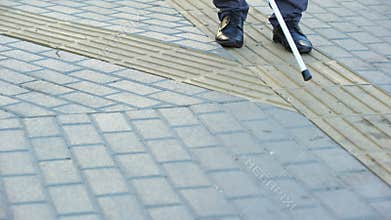 Impolite guy crossing road to blind man, impaired navigate with tactile paving