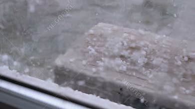 Hail Outside the Window. Hailstones fall on the air conditioner cover outside the window