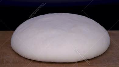Yeast dough rises time lapse. Pastry on cutting board on black background