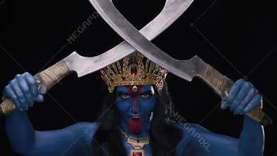 Ancient goddess Kali is crossing two blades and showing her red tongue