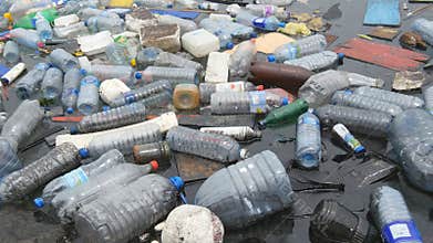 Environmental pollution. Plastic bottles, bags, trash in river, lake. Rubbish and pollution floating in water
