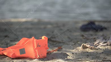 Life jacket lying on seashore, disaster area, catastrophe mortality statistics