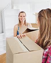 Two radiant female friends holding boxes