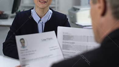 Female job candidate feeling nervous during interview, male manager reading cv