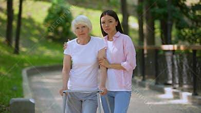 Sad aged patient walking frame and daughter looking camera, social insecurity