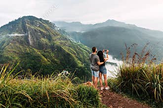 A couple in love travels to Sri Lanka. The couple travels the world. A man and a woman greet dawn in the Ella mountains, Sri Lanka