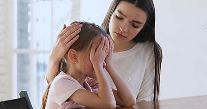 Caring worried young mum comforting sad crying child daughter