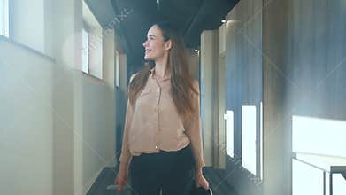 Happy woman with travel suitcase walking at hotel corridor