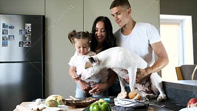 Family with huge dog preparing food in modern kitchen