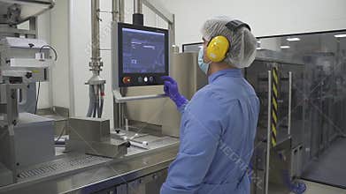 Man employee work with computer control production process in pharmaceutical factory.