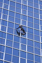 Man cleaning windows of modern business building