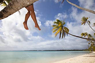 Women's legs on white sand beach